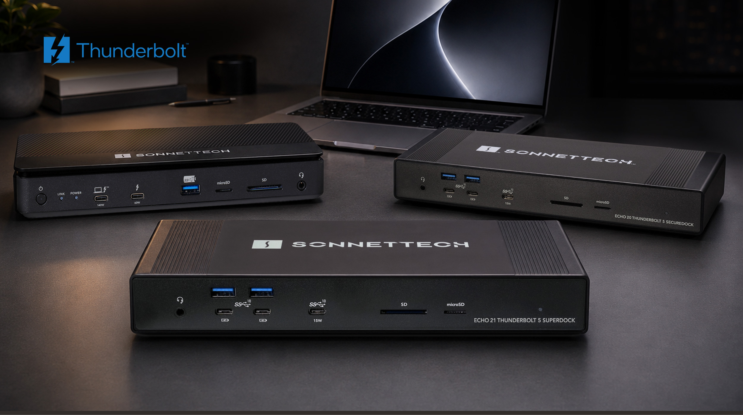 Group of Thunderbolt docks with MacBook Pro on desk.